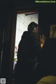 A man standing in front of a door with his hand on the door handle.