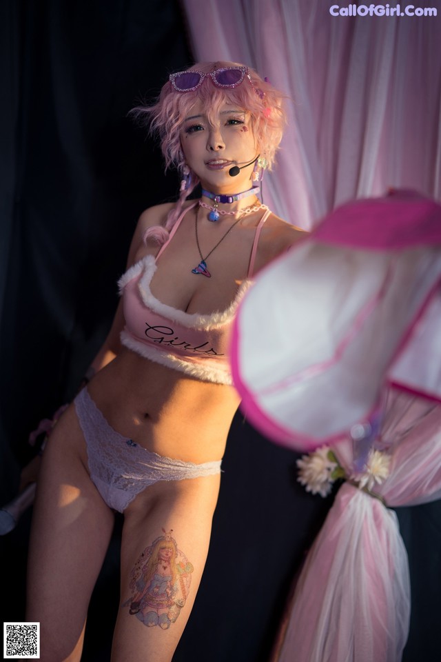 A woman in a pink lingerie holding a pink umbrella.