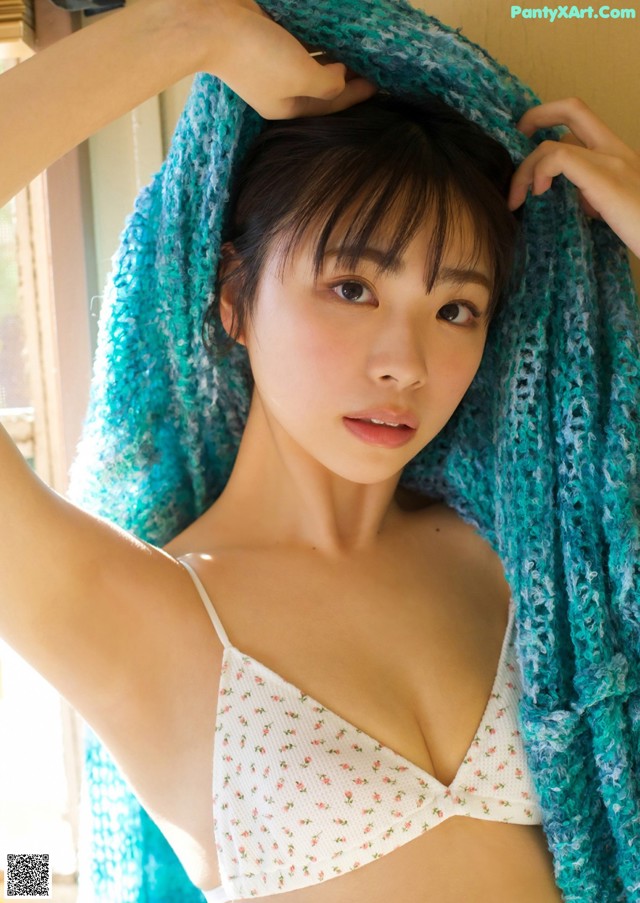 A woman in a white bra top and a blue scarf.