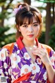 A woman in a purple and orange kimono posing for a picture.