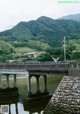 A bridge over a body of water with mountains in the background.