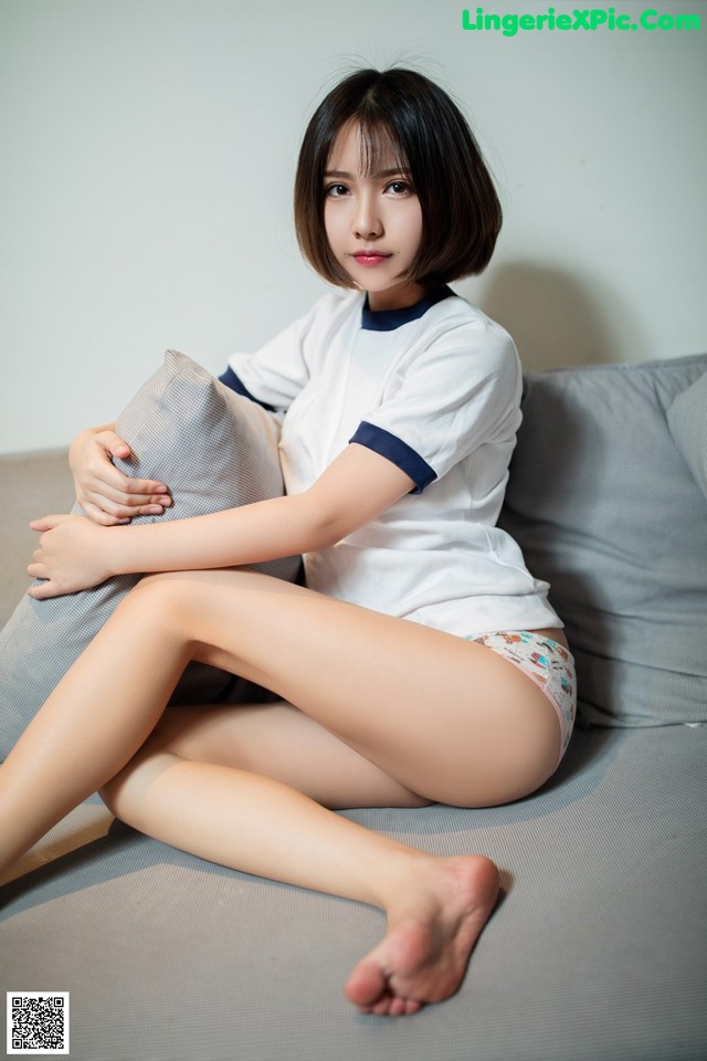 A woman sitting on a couch with her legs crossed.