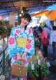 A woman in a blue and pink kimono holding a basket.