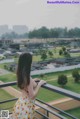 A woman standing on a balcony looking out over a city.