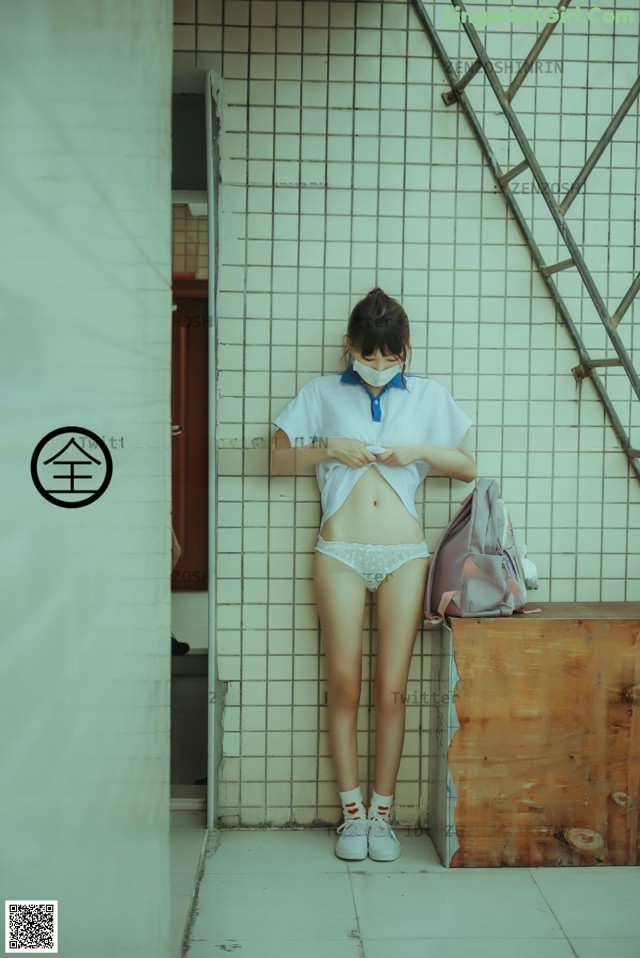 A woman wearing a face mask standing in a bathroom.